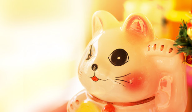 sunlight Maneki Neko cat. Common Japanese sculpture bring good luck to the owner over light [Blur and Select focus background]