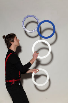  juggler with rings on a gray background