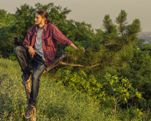 Young photographer sitting on the tree.