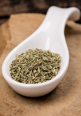 Fennel seeds in white spoon on stone
