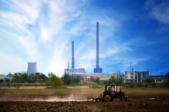 hdr industrial landscape with tracktor in farmland near big city 