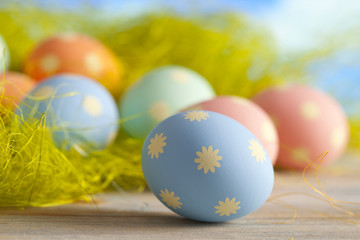 Colored Easter eggs in pastel colors on green and blue backgroun