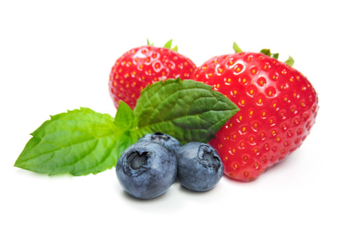 Strawberries, blueberries and mint leave, isolated on white.