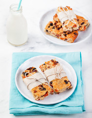 Granola, oatmeal, oat bars with dried cranberry and raisin on a white and blue background. Healthy breakfast