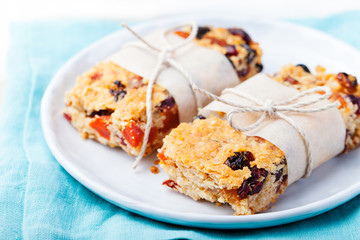 Granola, oatmeal, oat bars with dried cranberry and raisin on a white and blue background. Healthy breakfast