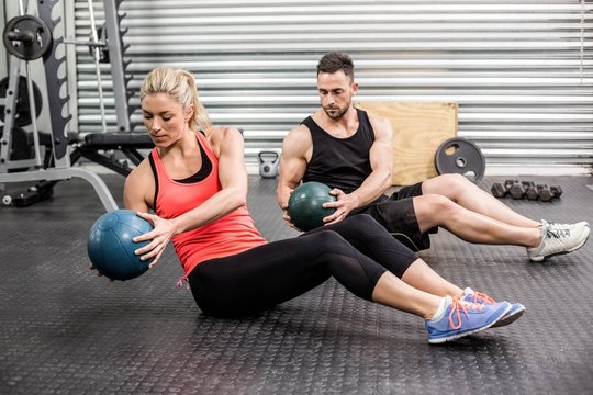 Fit couple doing abdominal ball exercise