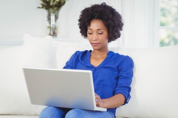 Obraz na płótnie Canvas Smiling woman using laptop