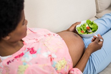 Obraz na płótnie Canvas Pregnant woman eating salad