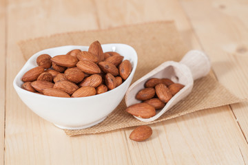 Almonds in bowl on wood
