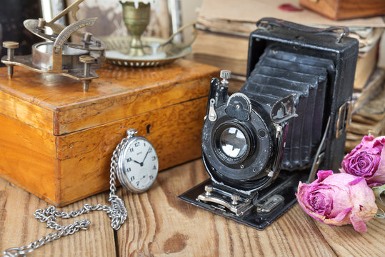 Vintage photo camera, pocket watches  and dried roses