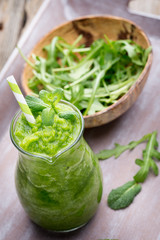 Rucola smoothie, on the grey  background.