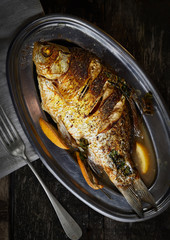 Baked carp fish on a metal plate
