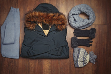 Set of beautiful winter female clothes on wooden background