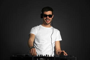 DJ playing music at mixer on grey background