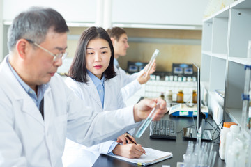 Fototapeta premium people doing chemical experiment in modern lab