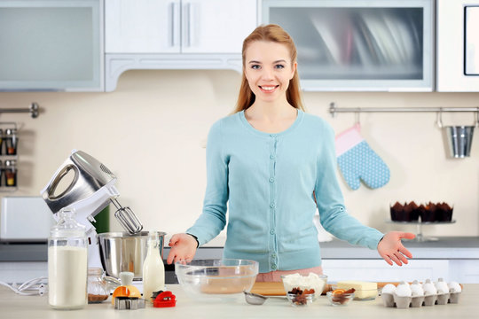 Young woman rolling out the dough on the kitchen counter
