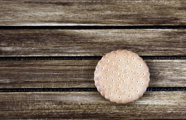 Single biscuit on wooden background