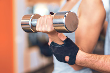 Young, beautiful girl training with the coach in the gym.