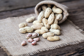 Peanut in sacks on the wooden background