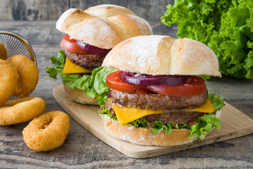 Delicious burger with cheddar cheese, tomato, lettuce and onion
