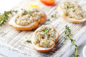 Bruschetta with green olives paste, tapenade on a white wooden background