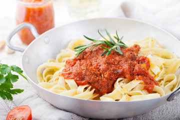 Tagliatelle pasta with tomato sauce and red pesto Italian cuisine 