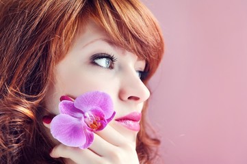 Beautiful girl holding orchid flower in her hands