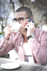 Happy handsome man at cafe drinking coffe.