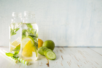 Infused water with citrus and herb in glass bottle