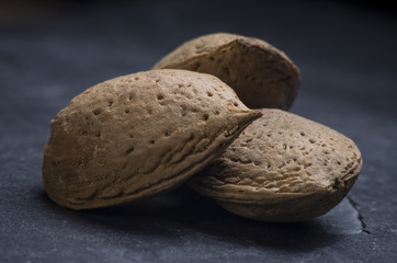 Almendras colocadas sobre una piedra de pizarra. Textura y nitidez.