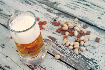 Beer in a glass on wooden background. Beer and beer snack.