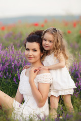 Happy mother and daughter in a field of blooming lavender