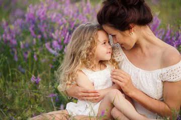 Happy mother and daughter in a field of blooming lavender