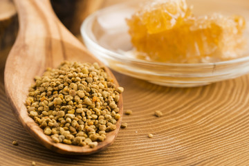 Fresh bee pollen in the spoon with honeycomb