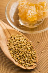 Fresh bee pollen in the spoon with honeycomb