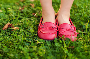 Close up of red moccasins on child's feet