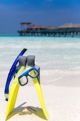 Taucherbrille und Flossen am Malediven Strand stehend