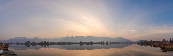Fototapeta na wymiar Beautiful panoramic scene at the sunrise of Nagin Bach / Nigeen lake with a row of boathouses. 