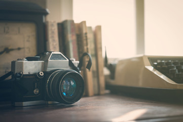Close up of vintage old camera, clock, books, typewriter with su