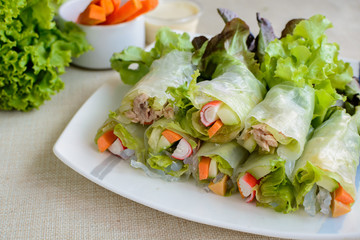 spring rolls with fresh vegetable on wooden table