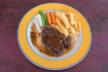 Grilled beef with pepper gravy with vegetables and french fries 