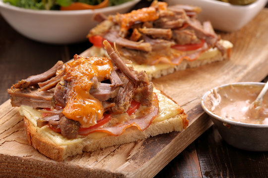 Sandwich with shredded pork on wooden table