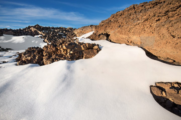 Winter scene of Teide national park at sunset with volcanic rocks and snow, in Tenerife, Canary islands, Spain.