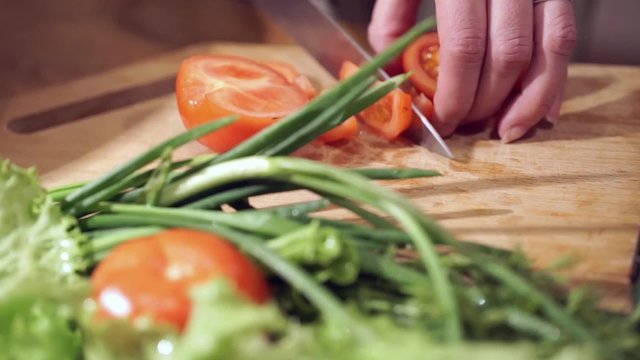 Cooking and home concept. Cutting tomato.