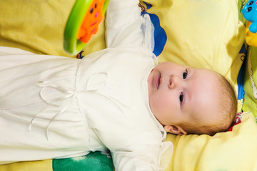 happy cute 4 month baby lying on the bed