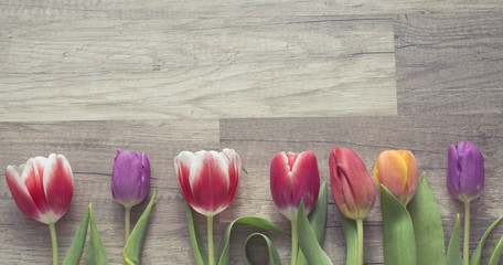 Photograph of a bunch of tulips on wooden surface