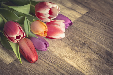 Photograph of a bunch of tulips on wooden surface