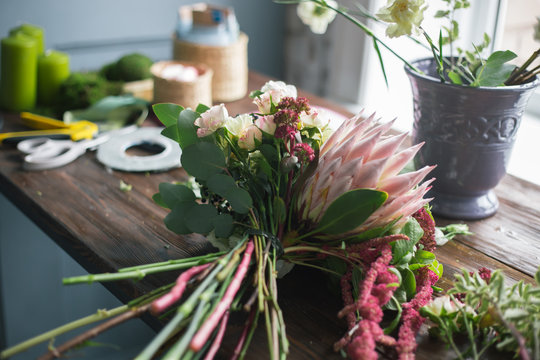 Florist workplace: flowers and accessories on a vintage wooden table. soft focus