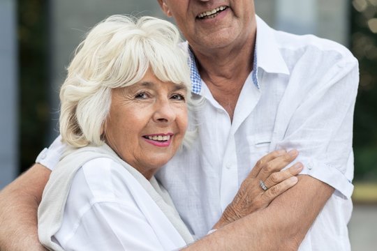 Senior woman hugging her husband
