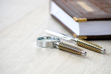 Stationery magnifying glass, paper knife and a notebook